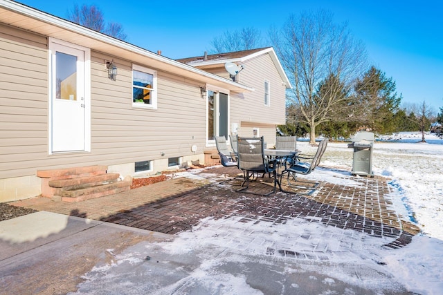 snow covered patio with a grill