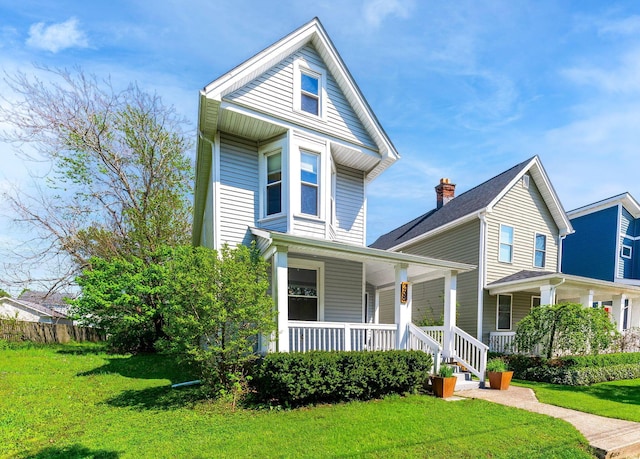 view of front facade featuring covered porch and a front yard