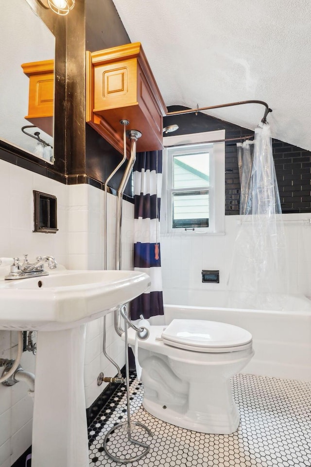 full bathroom featuring tile patterned flooring, shower / tub combo, toilet, and tile walls