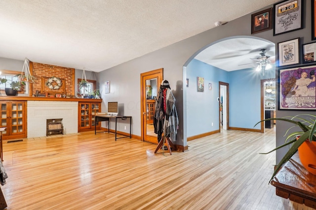 living room with ceiling fan, hardwood / wood-style floors, a healthy amount of sunlight, and a textured ceiling