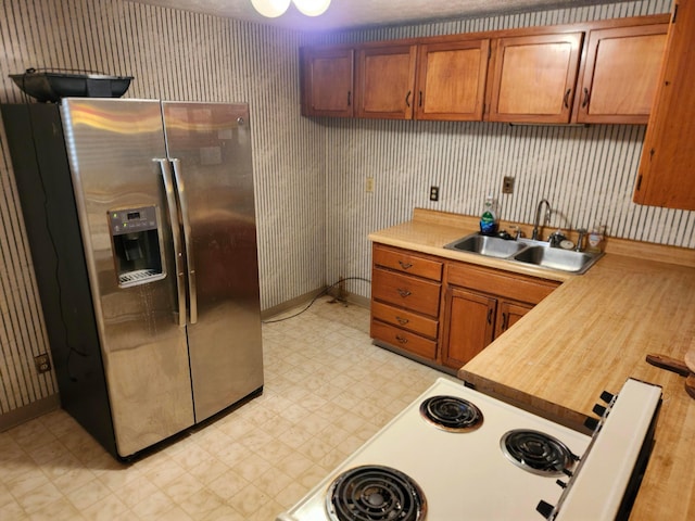 kitchen featuring stainless steel fridge with ice dispenser and sink