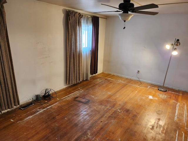 empty room with hardwood / wood-style floors and ceiling fan