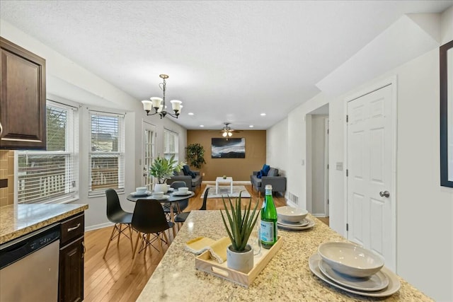 kitchen featuring pendant lighting, light hardwood / wood-style flooring, stainless steel dishwasher, light stone countertops, and dark brown cabinetry