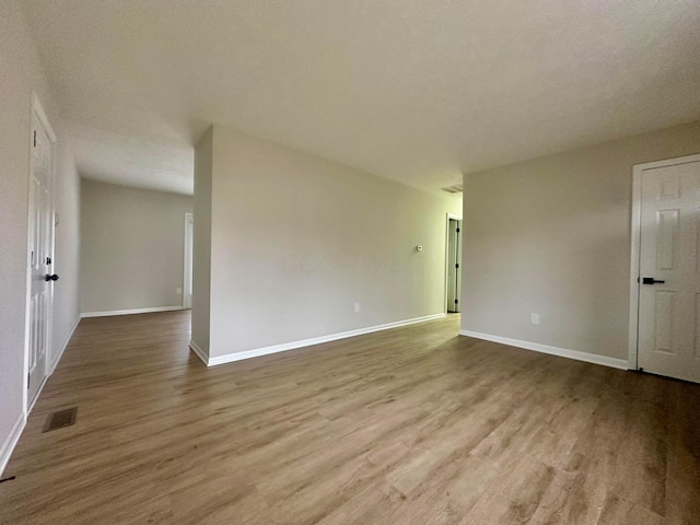 unfurnished room featuring a textured ceiling and light wood-type flooring