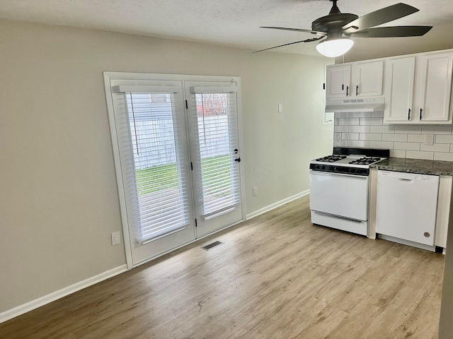 kitchen with white appliances, light hardwood / wood-style flooring, decorative backsplash, dark stone countertops, and white cabinetry