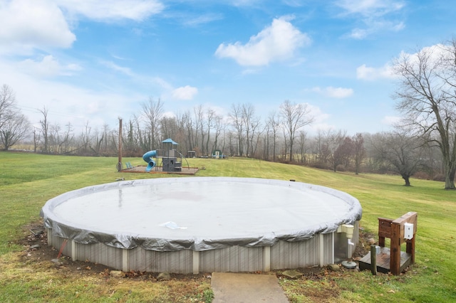 view of pool with a yard and a playground