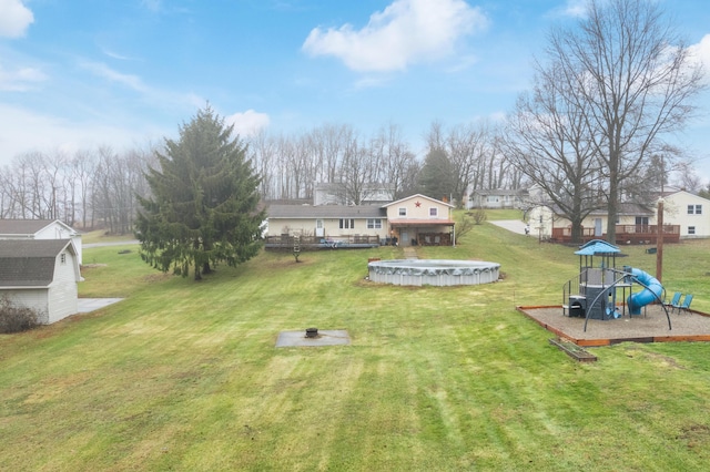 view of yard with a playground and a covered pool