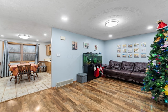 living room featuring wood-type flooring and a textured ceiling