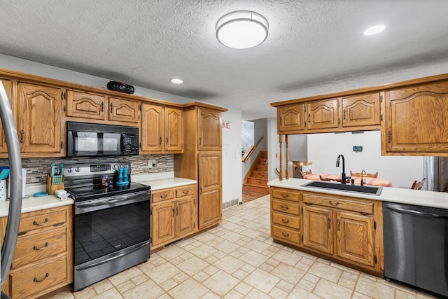 kitchen with backsplash, sink, a textured ceiling, and appliances with stainless steel finishes