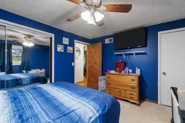 carpeted bedroom with a textured ceiling and ceiling fan