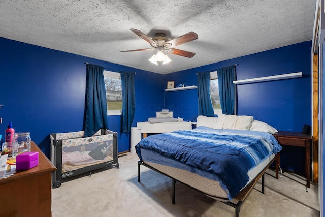 bedroom with a textured ceiling, carpet floors, and ceiling fan