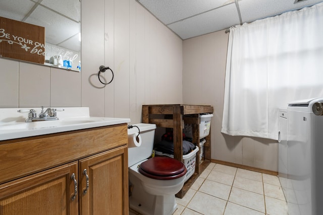 bathroom featuring tile patterned floors, a drop ceiling, vanity, and toilet