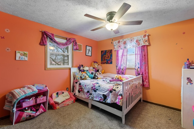 carpeted bedroom featuring ceiling fan and a textured ceiling