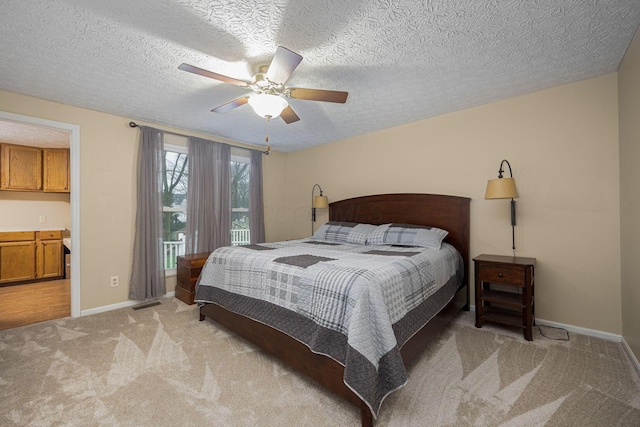 bedroom featuring ceiling fan, light colored carpet, and a textured ceiling