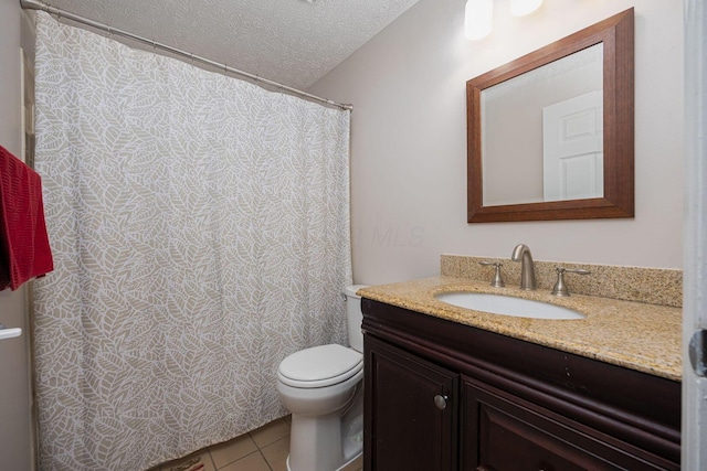 bathroom with tile patterned floors, vanity, a textured ceiling, and toilet