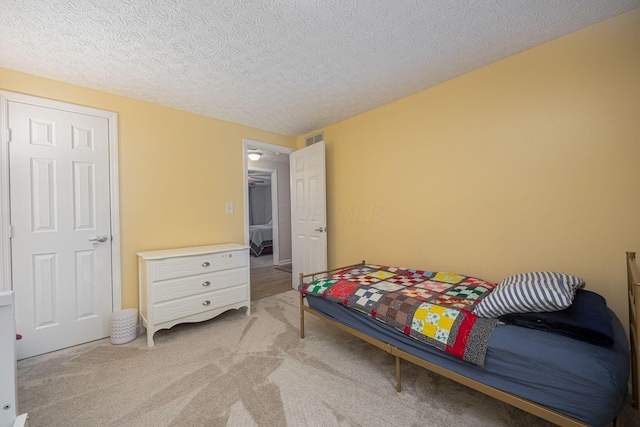 carpeted bedroom featuring a textured ceiling