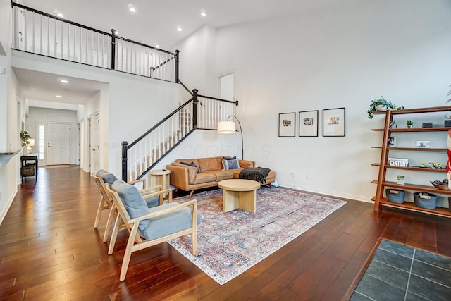 living room featuring dark wood-type flooring and a high ceiling