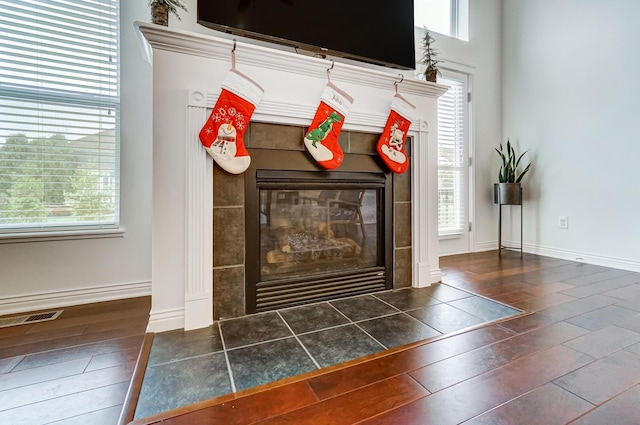 interior details featuring hardwood / wood-style floors and a tile fireplace