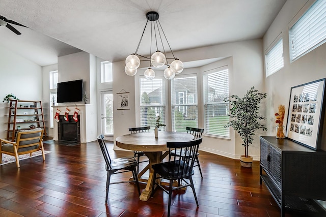 dining area with dark wood-type flooring and ceiling fan with notable chandelier