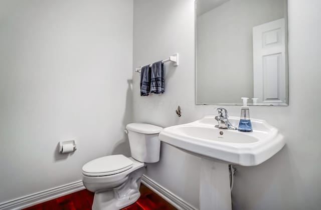 bathroom featuring hardwood / wood-style flooring and toilet