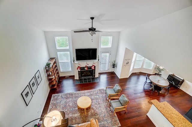 living room with ceiling fan, a fireplace, and dark hardwood / wood-style floors