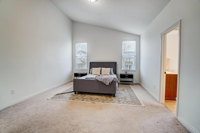 carpeted bedroom featuring connected bathroom and lofted ceiling