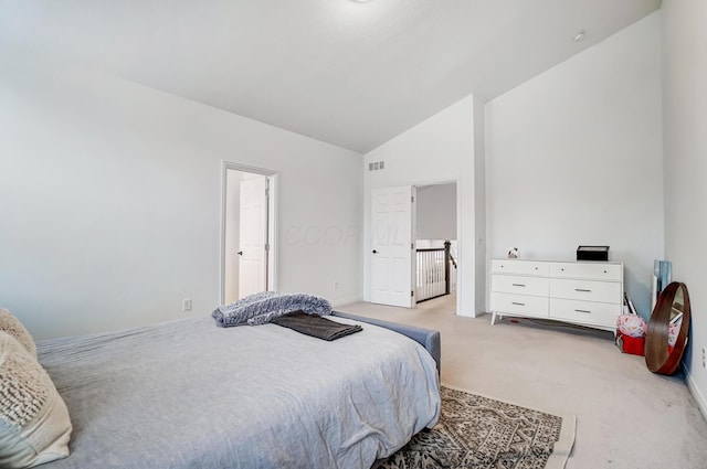 bedroom with light colored carpet and lofted ceiling