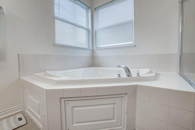 bathroom with tile patterned floors and tiled tub