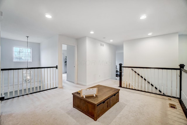 sitting room featuring light carpet and an inviting chandelier