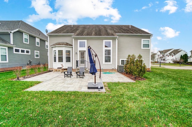 back of house featuring a lawn, central AC unit, and a patio