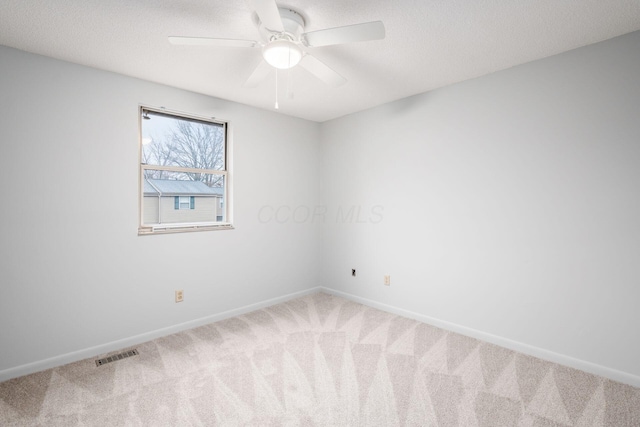 carpeted spare room with ceiling fan and a textured ceiling