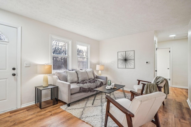 living room with wood-type flooring and a textured ceiling