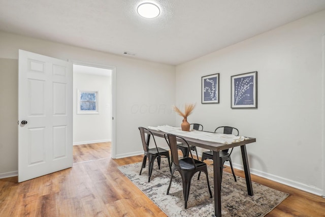 dining space featuring wood-type flooring