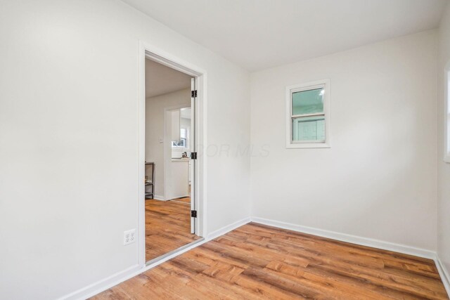 empty room with a healthy amount of sunlight and wood-type flooring