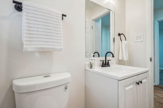 bathroom featuring hardwood / wood-style flooring, vanity, and toilet