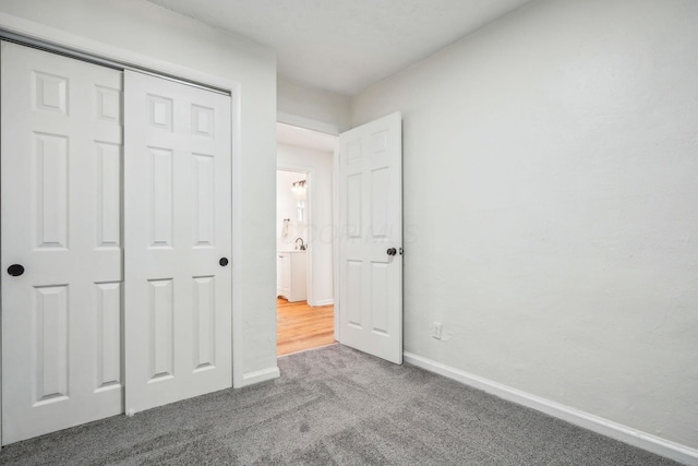 unfurnished bedroom with a closet and carpet floors