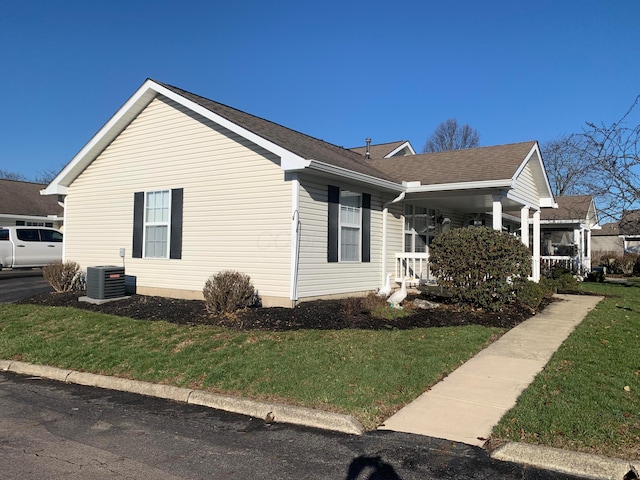 view of home's exterior featuring central AC, a porch, and a yard