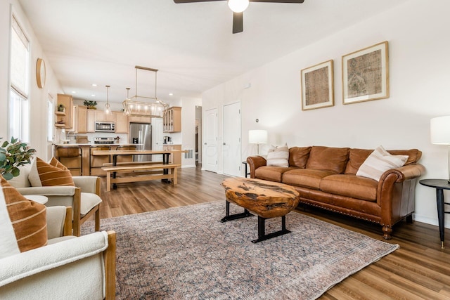 living room featuring ceiling fan and dark hardwood / wood-style flooring