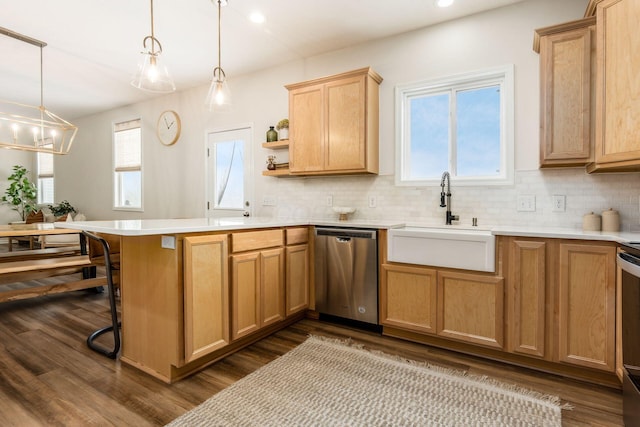 kitchen with a kitchen bar, pendant lighting, stainless steel dishwasher, and sink