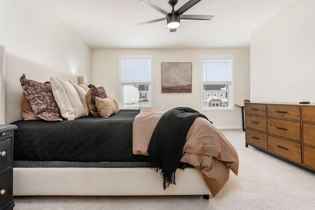 carpeted bedroom featuring multiple windows and ceiling fan