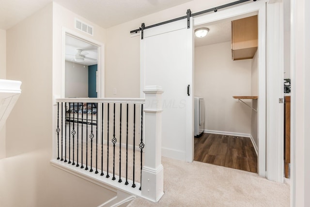 corridor with a barn door and carpet