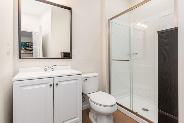 bathroom with vanity, toilet, and a shower with door