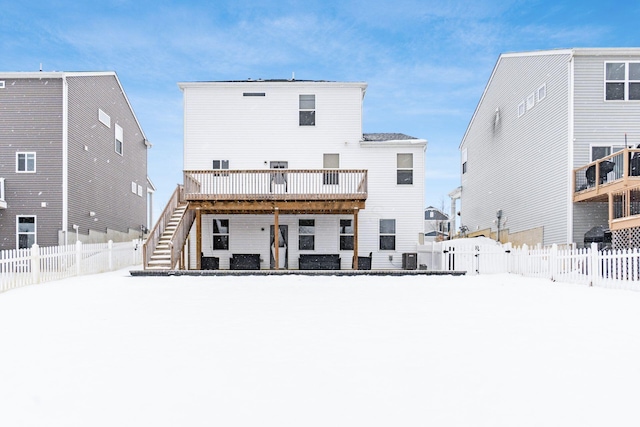 snow covered house with a wooden deck and central AC