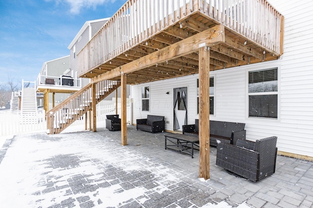 snow covered patio featuring a deck