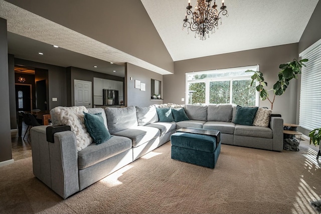 carpeted living room featuring a chandelier, a textured ceiling, and high vaulted ceiling