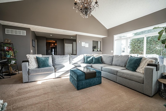 carpeted living room with high vaulted ceiling, a textured ceiling, and an inviting chandelier