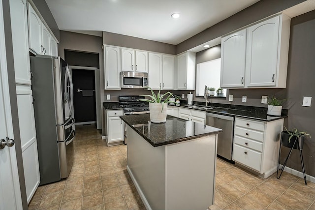 kitchen with a center island, dark stone counters, sink, white cabinetry, and stainless steel appliances