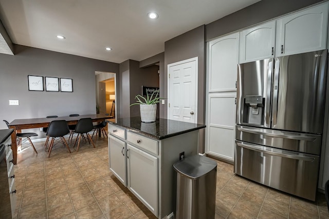 kitchen with white cabinets, stainless steel fridge with ice dispenser, and dark stone counters