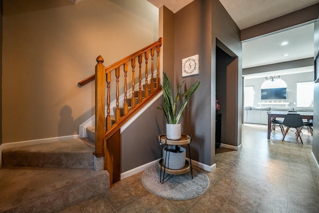 stairs with a textured ceiling