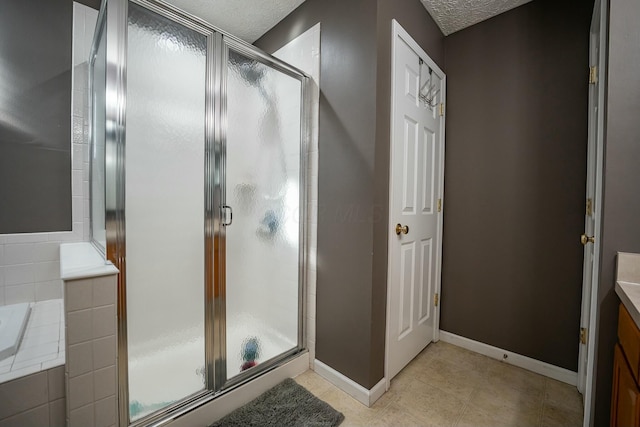 bathroom with vanity, a shower with door, and a textured ceiling